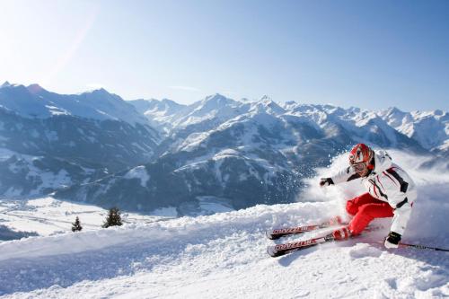 a person is skiing down a snow covered mountain at Hotel Flatscher in Stuhlfelden