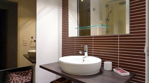 une salle de bain avec un lavabo et un miroir dans l'établissement Avenue Bugeaud - Paris 16, à Paris