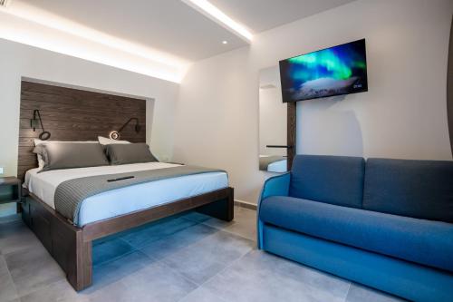 a bedroom with a bed and a couch and a television at Sylvia Camping & Luxury Suites, Panel Hospitality Homes & Villas in Litochoro