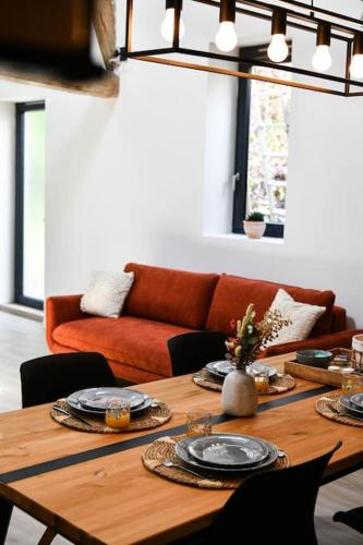 - une table en bois avec des assiettes dans le salon dans l'établissement Jacuzzi idyllique à 1h de Paris, à Greneville-en-Beauce