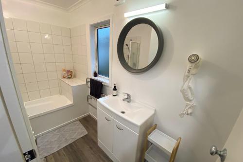 a white bathroom with a sink and a mirror at Bolton Executive Residence in Wellington