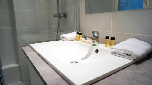 une salle de bain avec un lavabo blanc et une douche dans l'établissement Square Desaix - Paris 15, à Paris