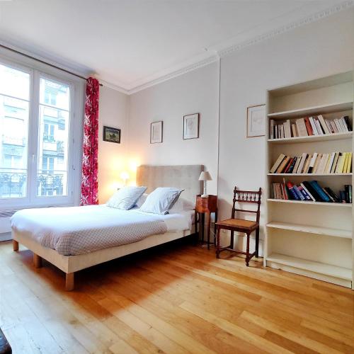 une chambre avec un lit et une étagère dans l'établissement Square Desaix - Paris 15, à Paris