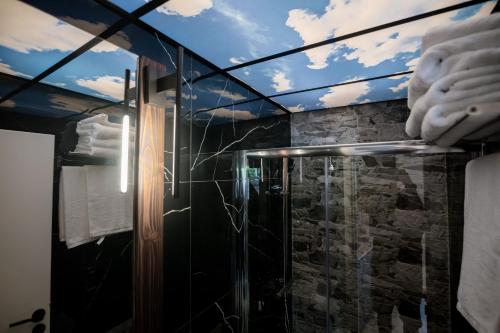 a bathroom with a shower with a glass wall at Sylvia Camping & Luxury Suites, Panel Hospitality Homes & Villas in Litochoro