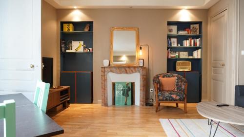 un salon avec une cheminée et un miroir dans l'établissement Rue du Faubourg Saint Honore - Paris 8, à Paris