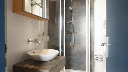 une salle de bain avec un lavabo et une douche dans l'établissement Rue du Faubourg Saint Honore - Paris 8, à Paris