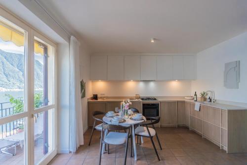 a kitchen with a table and chairs and a window at Casa Vela by Rent All Como in Sala Comacina