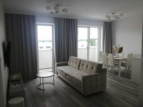una sala de estar con un sofá y una mesa en Apartament na Letniej Klimatyzacja, en Kłodzko