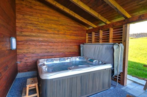 a hot tub in a sauna with a wooden wall at 5 Sterne Ferienhaus Bayern in Untergriesbach