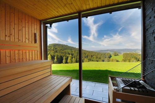 a screened in porch with a bench and a large window at 5 Sterne Ferienhaus Bayern in Untergriesbach