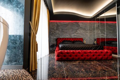a red couch sitting in the middle of a room at AMJ Royal Apartments - 115 - Black Rubby in Kaunas