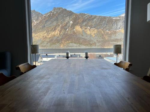 a large table with chairs and a view of a mountain at FeelSenja Gryllefjord Holiday House in Gryllefjord