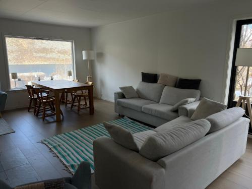 a living room with a couch and a table at FeelSenja Gryllefjord Holiday House in Gryllefjord