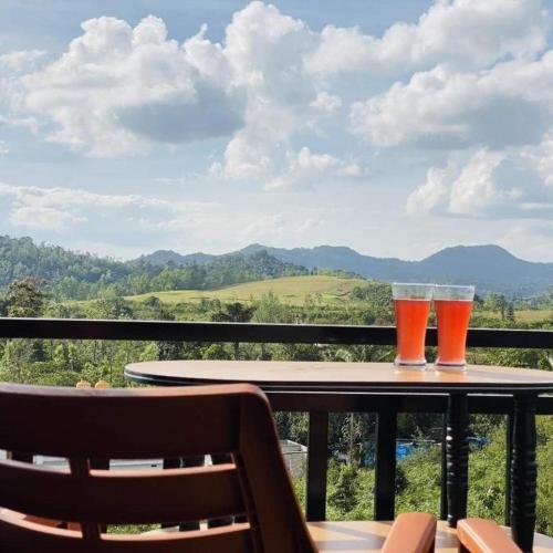 two glasses of beer sitting on a table on a balcony at coorg mist greens in Madikeri