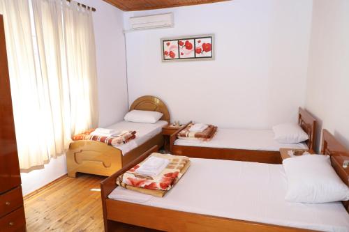 a room with two beds and a table and a window at Stergjo Townview Residences in Berat