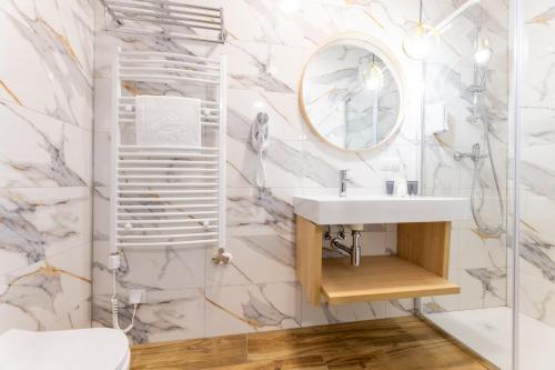 a bathroom with a sink and a mirror at Awilla Ustka in Ustka