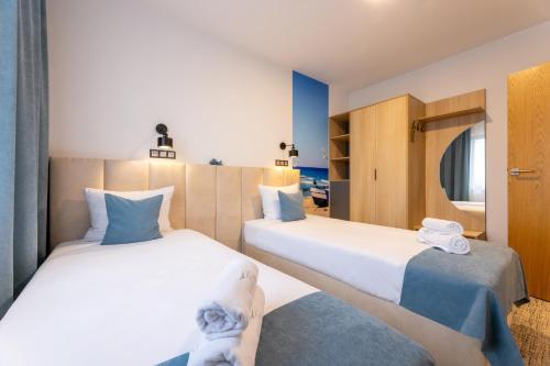 a bedroom with two beds and a mirror at Awilla Ustka in Ustka