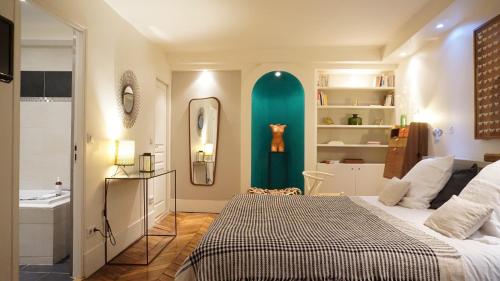 une chambre avec un grand lit et un miroir dans l'établissement Rue de Penthièvre - Paris 8, à Paris