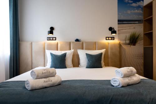 a bedroom with a large bed with three pillows on it at Awilla Ustka in Ustka
