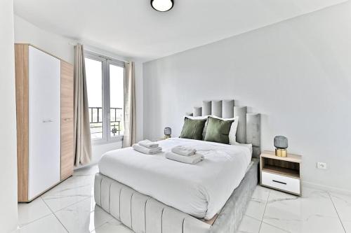 une chambre blanche avec un grand lit et une fenêtre dans l'établissement Séjour Authentique près de Paris à Gagny - II, à Gagny