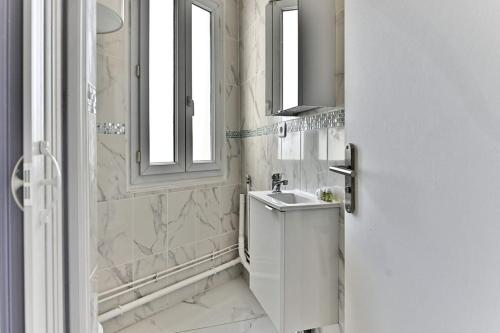 une salle de bain blanche avec un lavabo et une douche dans l'établissement Séjour Authentique près de Paris à Gagny - II, à Gagny
