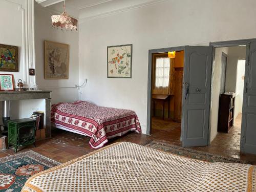 Les Asphodeles chambre familiale Lilah في سانت هيبوليت - دو - فورت: غرفة معيشة بها سريرين ومدفأة