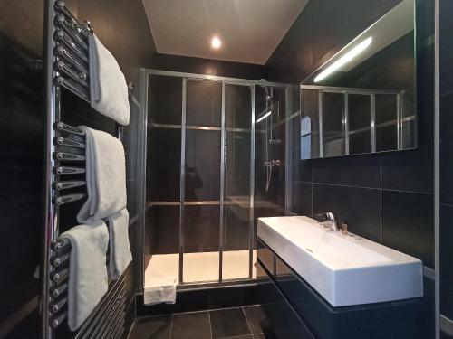 une salle de bain avec un lavabo et une douche dans l'établissement Rue Jean Bart - Paris 6, à Paris