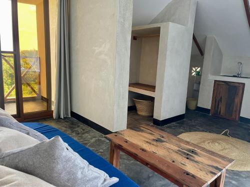 a living room with a couch and a wooden table at Baobab Bungalows in Jambiani