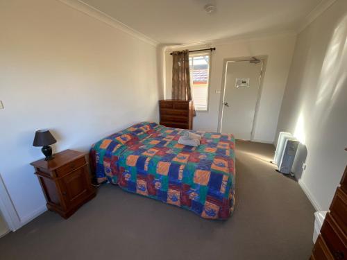 a small bedroom with a bed and a dresser and a bed sidx sidx sidx at San Michele Adaminaby in Adaminaby