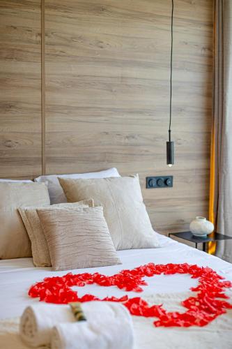 - un lit blanc avec des fleurs rouges en haut dans l'établissement Le Reflet du Lac, à Tresserves