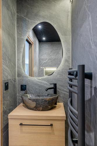 une salle de bain avec un lavabo et un miroir dans l'établissement Le Reflet du Lac, à Tresserves