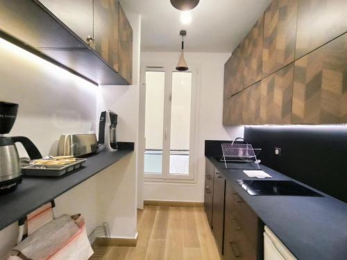 une cuisine avec un comptoir noir et une fenêtre dans l'établissement Rue du Faubourg St Honore #1 - Paris 8, à Paris