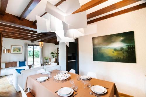 une salle à manger avec une table et un lustre dans l'établissement Villa sous les pins, plage à pied! Seignosse Océan, à Seignosse