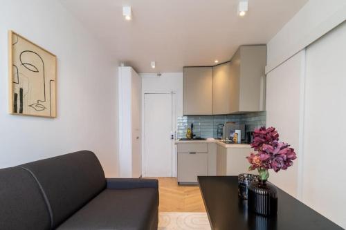 un salon avec un canapé et une table avec des fleurs dans l'établissement Cozy modern-Paris7-Tour Eiffel-Champs de mars, à Paris