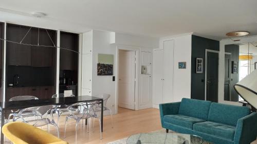 un salon avec une table et des chaises dans l'établissement Rue de l'Université - Paris 7, à Paris