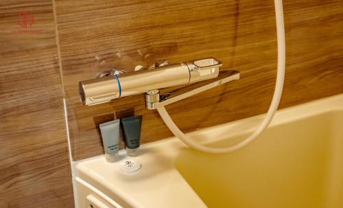 a hose hooked up to a toilet in a bathroom at DH Japan Hotel in Ha Long