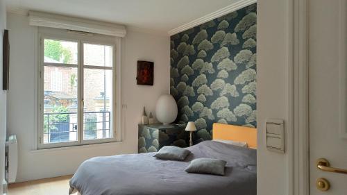 une chambre avec un lit et une fenêtre dans l'établissement Rue de l'Université - Paris 7, à Paris