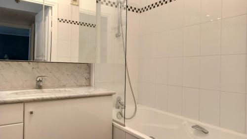 une salle de bain blanche avec une douche et un lavabo dans l'établissement Rue de l'Université - Paris 7, à Paris