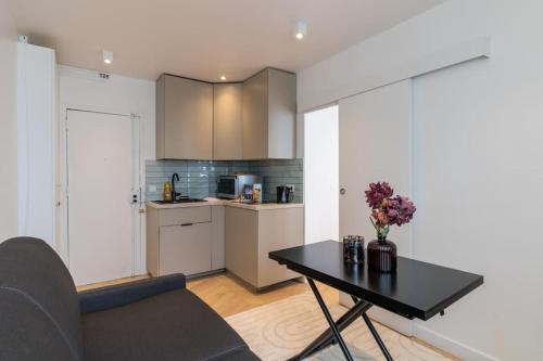 un salon avec une table et une cuisine dans l'établissement Cozy modern-Paris7-Tour Eiffel-Champs de mars, à Paris