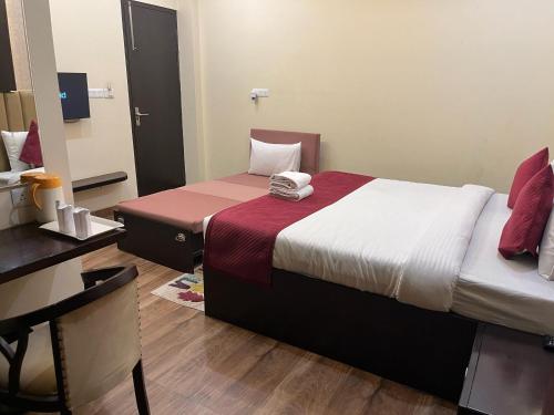 a hotel room with a bed and a mirror at Mayur Palace Hotel in Agra