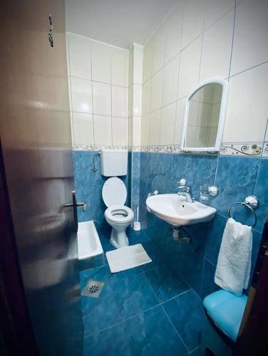 a blue and white bathroom with a toilet and a sink at Apartments Dunja in Sveti Stefan