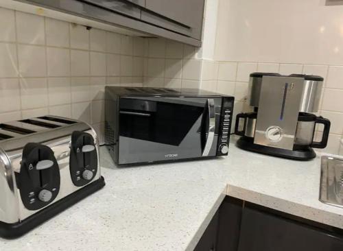 a kitchen counter with a microwave and a toaster oven at Pudding Chare by Gibson Rentals near train station in Newcastle upon Tyne