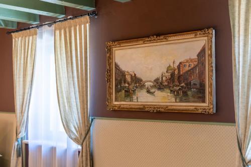 a painting hanging on a wall next to a window at Residenza Villa Vecelli Cavriani in Mozzecane