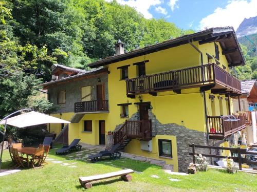 a yellow building with balconies and a table and chairs at Maison du Soleil- CIR VDA Valtournenche n 0204 in Valtournenche