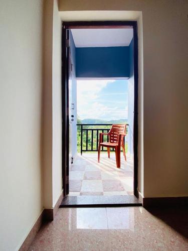 an open door to a balcony with a chair at coorg mist greens in Madikeri