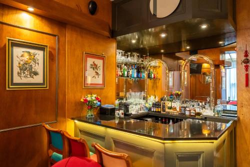 a bar in a restaurant with a counter and chairs at Hotel La Place in London