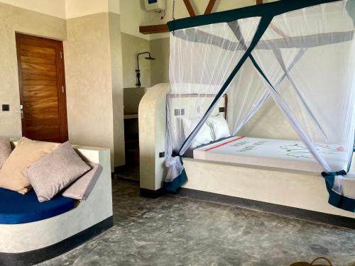 a room with two bunk beds and a door at Baobab Bungalows in Jambiani