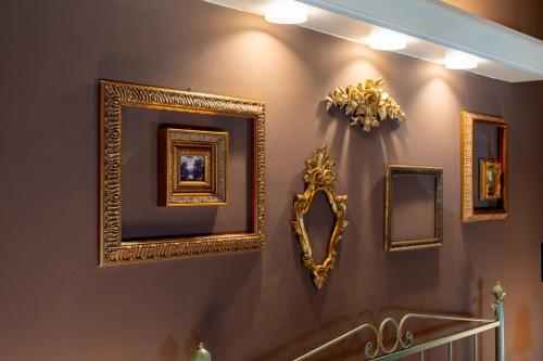 a bathroom with gold frames on the wall at Residenza Villa Vecelli Cavriani in Mozzecane