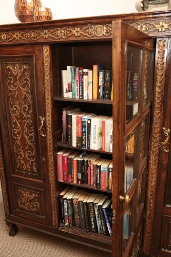 a wooden book shelf filled with books at Misty Waves Boutique Hotel in Hermanus