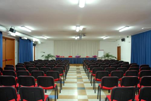 an empty lecture hall with red chairs and blue curtains at Park Hotel Villa Americana in Rodi Garganico